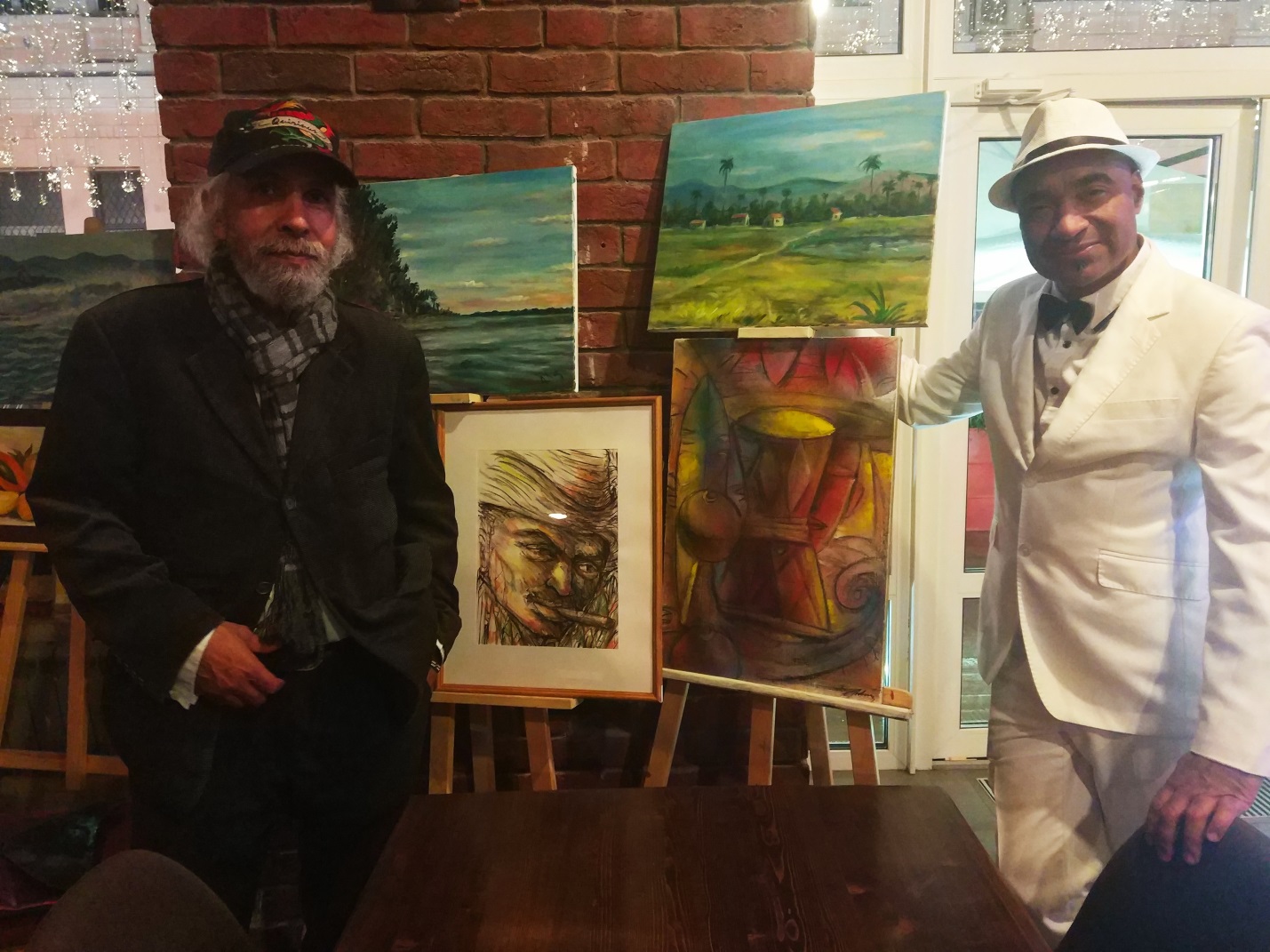 Кубинский режиссёр Эдуардо Пальет (справа) около выставки картин 
                кубинского художника Омара Годинеса. 20.10.2021 г.
