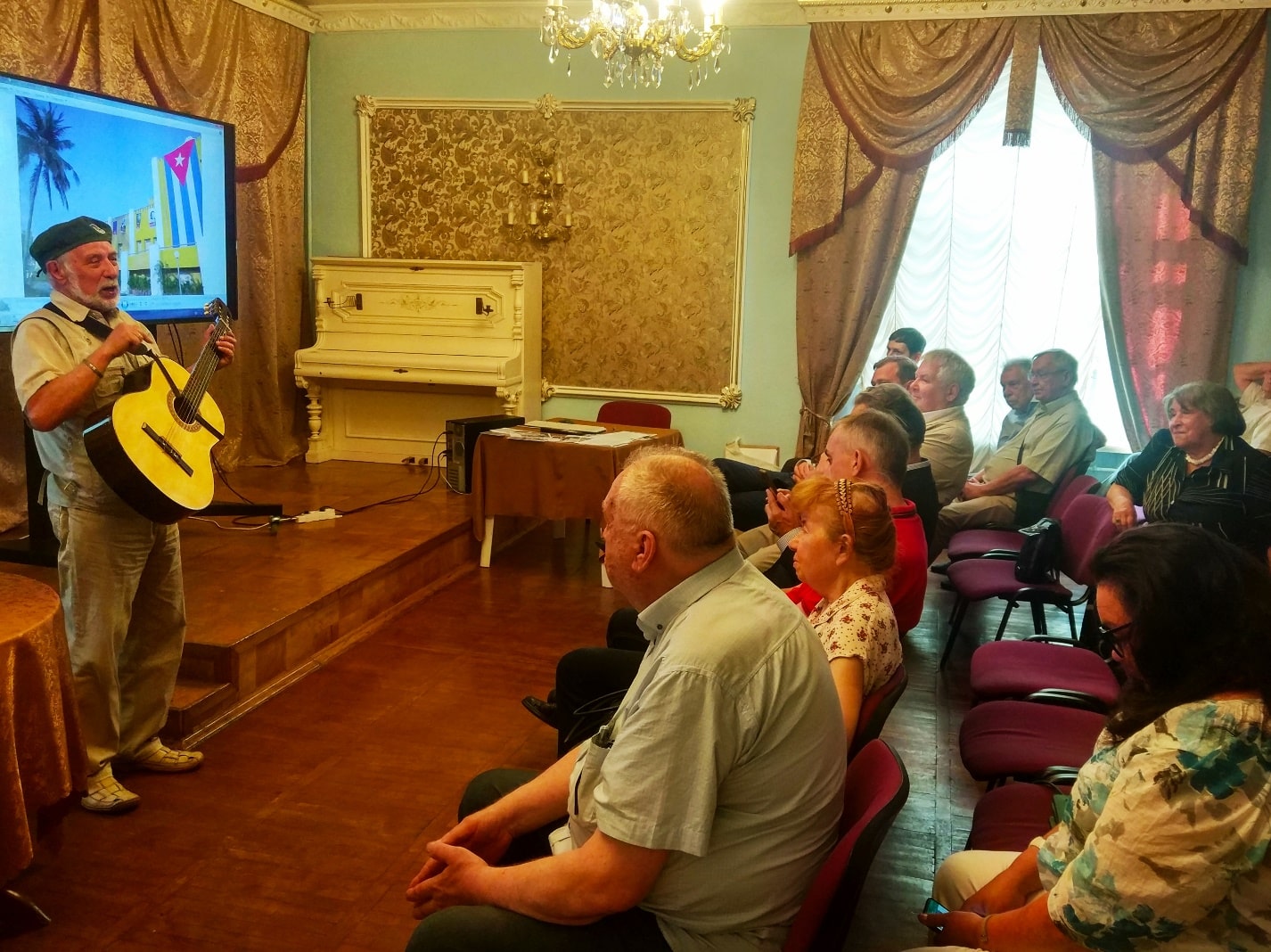 На фото:Владимир Иванович Солдатов, художник-карикатурист, журналист исполняет под гитару песни: «Марш 26 июля» и «Куба-любовь моя!» .